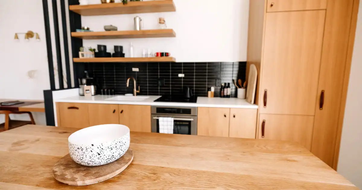 Cozy kitchen with a natural wood kitchen island and black tile backsplash