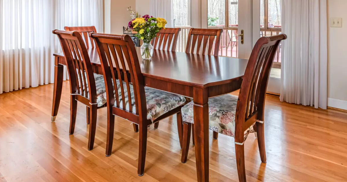 Elegant wooden dining table set with six chairs ideal wooden furniture for small spaces placed in a well lit dining room with large windows