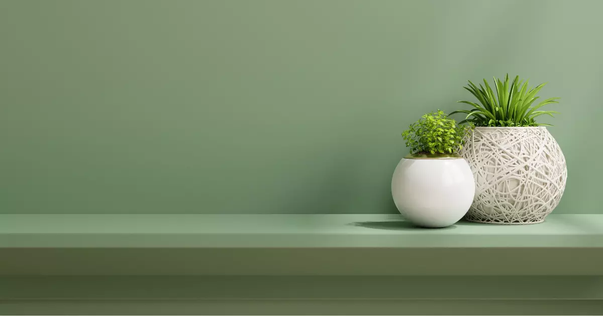Minimalist space saving wall table with modern planters placed against a green wall perfect for compact interiors