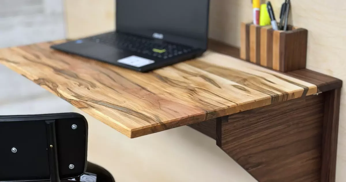 Stylish wooden space saving wall table used as a compact home office desk with laptop and stationery