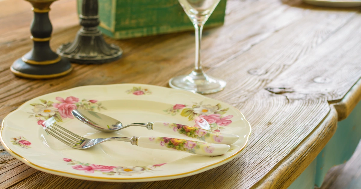 Vintage plate and utensils on rustic wood surface styled with farmhouse dining tables