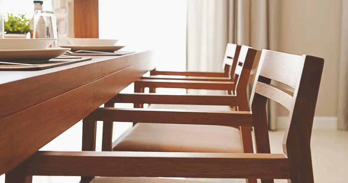 Handcrafted wood chairs tucked under a solid wood dining table with clean modern lines