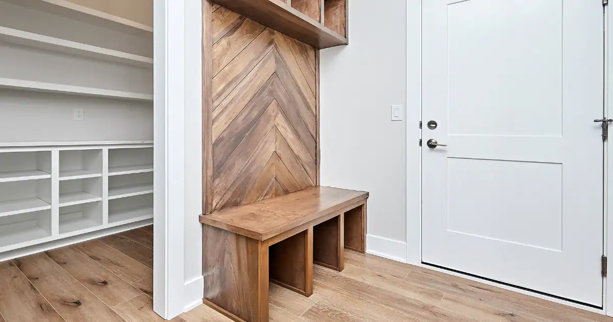 Wooden bench and cubbies with stylish mudroom shelving near the entry door